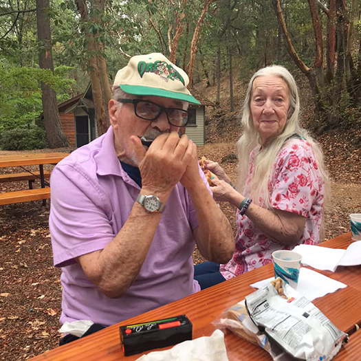 A man and a woman sitting at a picnic table.